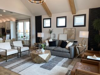 Model Home A modern living room featuring exposed beams, geometric furniture, and stylish lighting.
