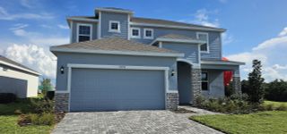 A stunning two-story blue home with stone accents and a paved driveway in Leela Reserve by Park Square Residential (Tavares, FL).