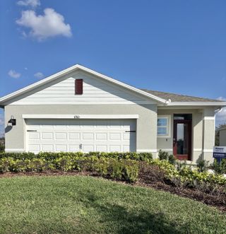 A charming white home with a manicured lawn in Harmony West by D.R. Horton (St. Cloud, FL).