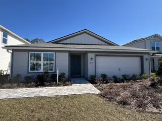 A charming single-story home with a manicured front yard in Wells Landing by Centex (Jacksonville, FL).