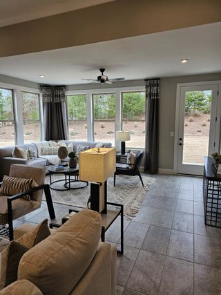 A serene living room with large windows, neutral tones, and stylish furnishings, creating a relaxing indoor-outdoor feel.