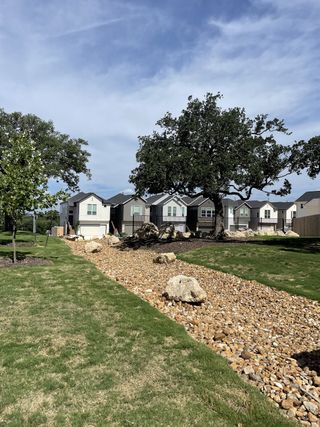 Charming homes with lush landscaping and rock pathways in Rose Hill by Chesmar Homes (San Antonio, TX).
