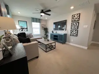 Model Home A cozy living room with a modern sofa, vibrant art, and a sleek entertainment center.