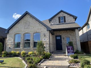 Charming stone and brick home with lush landscaping in Solterra by Impression Homes (Mesquite, TX).