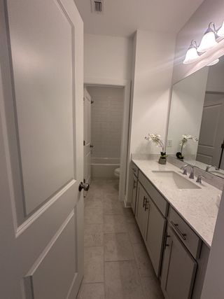A sleek bathroom with elegant fixtures, a spacious vanity, and warm lighting creating a modern and inviting atmosphere.