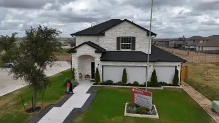 Model Home Elegant stone-accented home with manicured lawn in Cool Water by CastleRock Communities (Jarrell, TX).