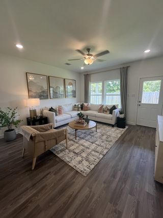 Model Home A cozy living room with a spacious white sectional, chic decor, and large windows offering natural light.