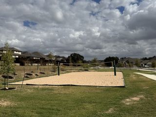 A scenic sand volleyball court surrounded by greenery, perfect for active outdoor recreation.