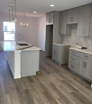 A second view of the spacious kitchen showcasing open-concept design, ample storage, and a stylish backsplash.