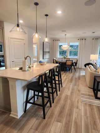 A modern kitchen with pendant lighting, bar seating, and an open-concept layout.