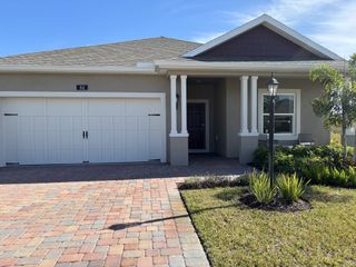 A charming home with a spacious garage and landscaped yard in Spirit Of Sebastian by Holiday Builders (Sebastian, FL).