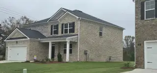 A beautiful brick home with a manicured lawn in Broder Farm by D.R. Horton (Stockbridge, GA).