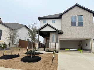 A modern two-story home with a landscaped yard in Turner's Crossing - Terrace Collection by Tri Pointe Homes (Austin, TX).