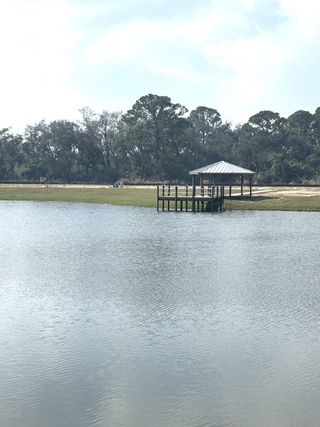 Stunning lake view with a gazebo and dock. Surrounded by trees, the serene setting offers a peaceful retreat by the water.