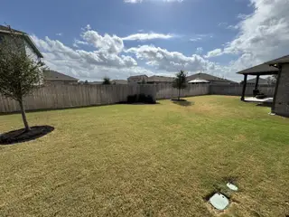Model Home Expansive green backyard with a cozy patio in the Village at Manor Commons by Pacesetter Homes (Manor, TX).