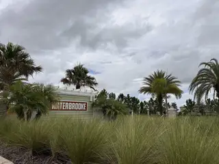Lush entrance with palm trees in Waterbrooke by Mattamy Homes, Clermont, FL. A welcoming community atmosphere.