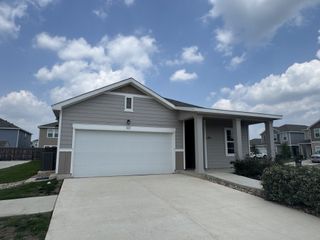 Street view A charming gray home with a spacious driveway in Hymeadow by Starlight Homes, Maxwell, TX.