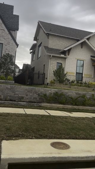 A modern home with elegant brickwork and a manicured yard in Mustang Lakes – 86’ by Tradition Homes (Celina, TX).