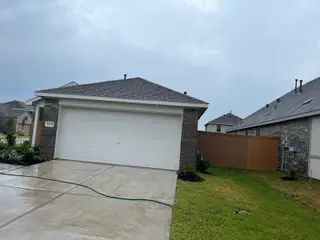 A charming brick home with a two-car garage and fresh landscaping in Sunterra by Lennar (Katy, TX).