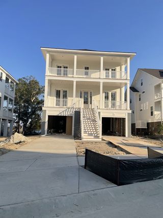 A classic white coastal home with spacious balconies in Wando Village by John Wieland (Charleston, SC).