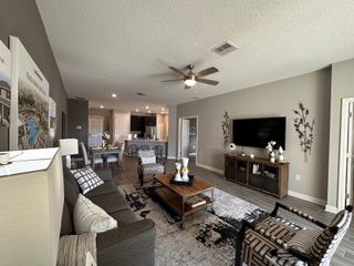 A spacious open-concept living room with modern decor and a stylish entertainment setup.