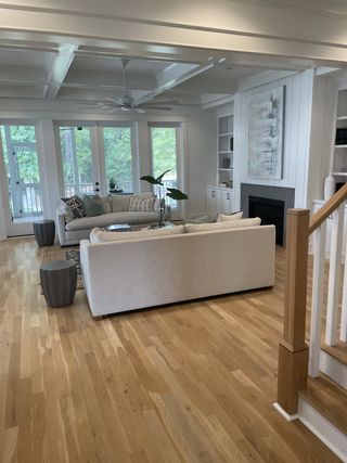 A bright living room with cozy seating, a modern fireplace, and natural light through large windows.