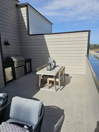 A private rooftop terrace with a built-in grill, dining set, and cozy lounge seating, perfect for outdoor entertaining.