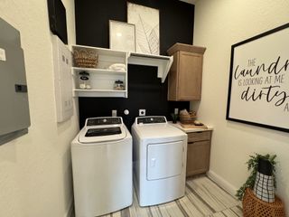 A modern laundry room with open shelving, stylish décor, and ample storage in Veramendi by Brightland Homes (New Braunfels, TX).