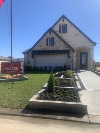 Street view A charming brick home with elegant landscaping in Amira: Hilltop Collection by Beazer Homes (Tomball, TX).