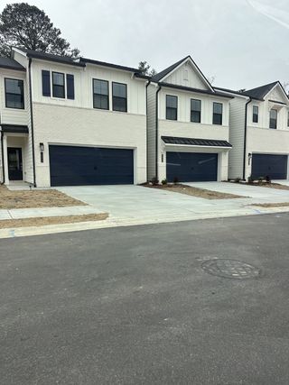 Street view Modern townhomes with white brick and dark accents in Azalea Square Townhomes by Century Communities, Lawrenceville, GA.