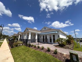 A charming white home with a lovely porch and manicured lawn in Osprey Ranch by K. Hovnanian® Homes (Winter Garden, FL).