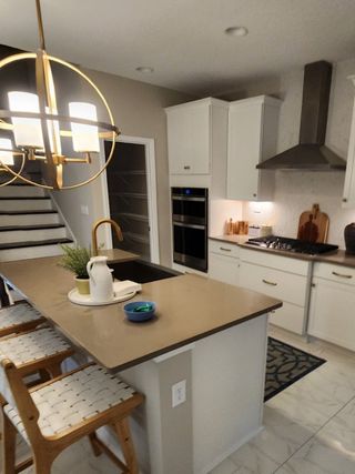 Model Home Modern kitchen with sleek cabinetry, quartz island, stylish lighting, and elegant fixtures.