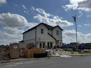 A modern two-story home with a stone façade in Village at Manor Commons by Landsea Homes (Manor, TX).
