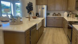 A modern kitchen with sleek stainless appliances, a farmhouse sink, and elegant cabinetry.
