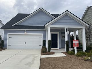 Street view A charming blue home with white trim and a spacious garage in Heron's Walk at Summers Corner by Lennar (Summerville, SC).
