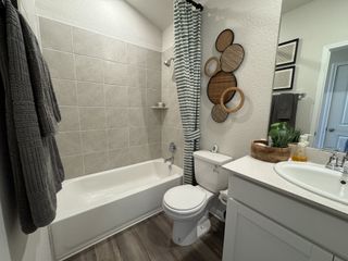 A modern bathroom featuring a tiled shower, stylish decor, and sleek fixtures, exuding contemporary elegance.