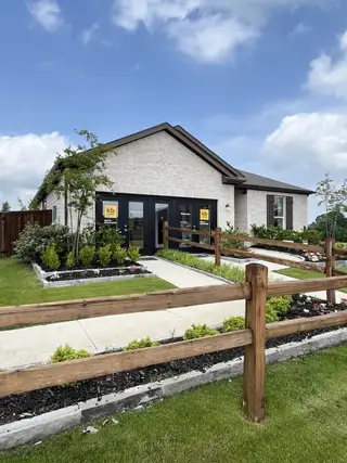 Street view A charming modern home with manicured landscaping in Heartland by KB Home (Heartland, TX).