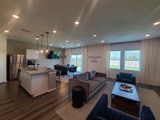 Model Home Open-concept living area with modern kitchen, cozy seating, contemporary dining, and ample natural light.