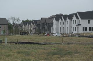A modern row of homes with gabled roofs in Painted Tree - Village District by CB JENI Homes (McKinney, TX).