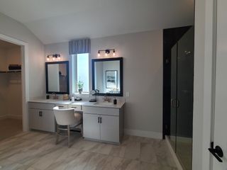 A modern bathroom featuring dual vanities, elegant lighting, and a glass shower, exuding sophistication and style.