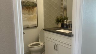 A modern bathroom with hexagonal tile, sleek vanity, and abstract art adding a touch of elegance.