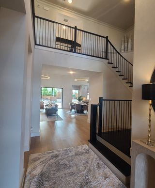 A chic open-concept living space with a sleek staircase, high ceilings, and elegant furnishings.