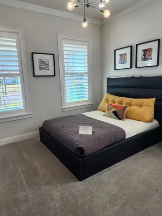 A stylish bedroom featuring bold yellow accents, sleek furniture, and modern lighting in a cozy setting.