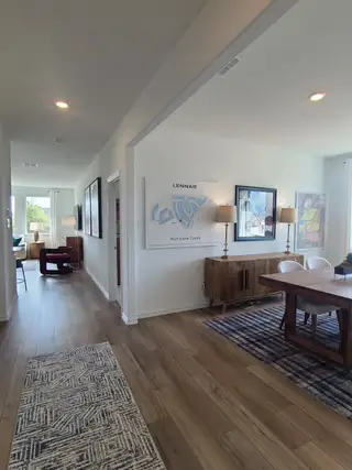 Model Home A modern dining area with sleek wood floors, stylish lighting, and contemporary wall art.