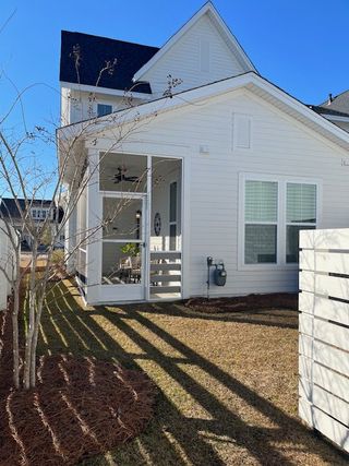 Charming white home with a cozy porch and landscaped yard in Nexton - Midtown by Saussy Burbank (Summerville, SC).
