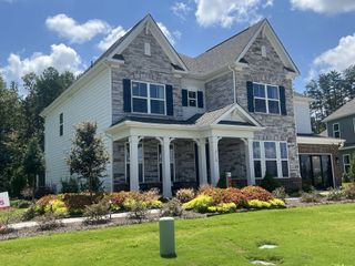 Street view A beautiful stone-accented home with manicured landscaping in Estates at Sugar Creek by Taylor Morrison (Indian Land, SC).