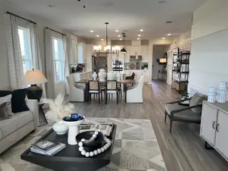 Modern open-concept living space with a cozy lounge, elegant dining area, and a sleek kitchen, featuring stylish decor accents.