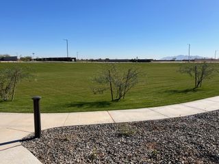 A lush green park with scenic mountain views in Windrose by Brightland Homes, Waddell, AZ.