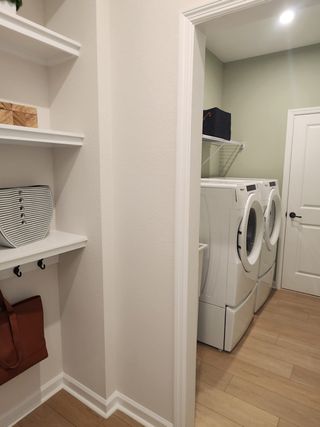 Model Home A sleek laundry room with modern appliances, neutral walls, and practical shelving for organized storage.
