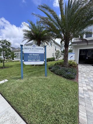 Street view A modern home with lush landscaping and palm trees in Reflections at Seabrook by ICI Homes (Nocatee, FL).